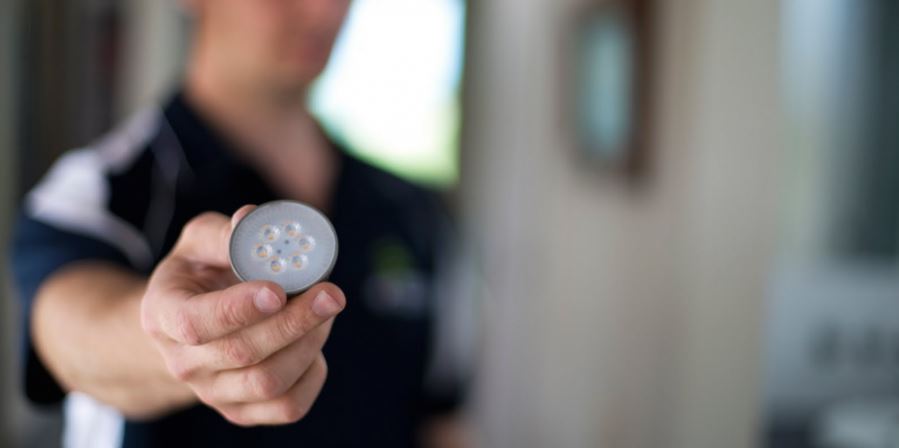 electrician holding a downlight