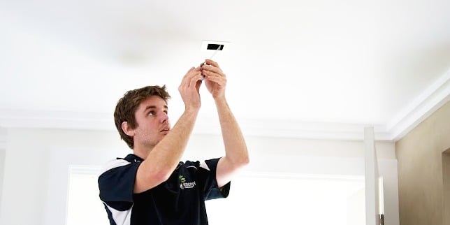 Electrician installs a light